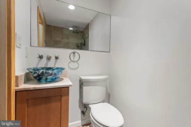 a bathroom with a toilet sink and mirror