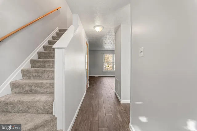 a view of a hallway with wooden floor and staircase
