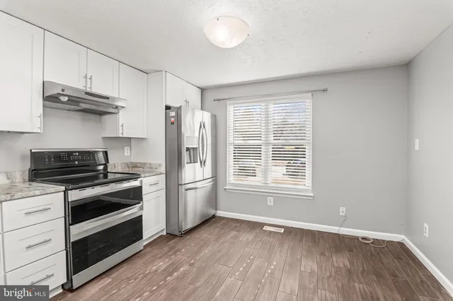 a kitchen with stainless steel appliances a stove a microwave and cabinets