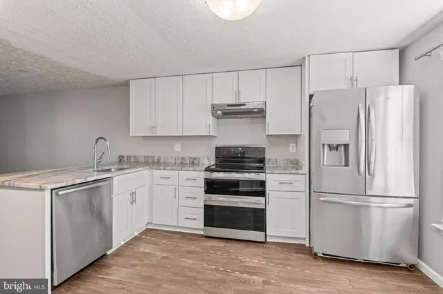 a kitchen with a refrigerator stove and white cabinets