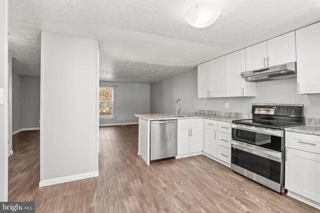 a kitchen with granite countertop white cabinets and white appliances