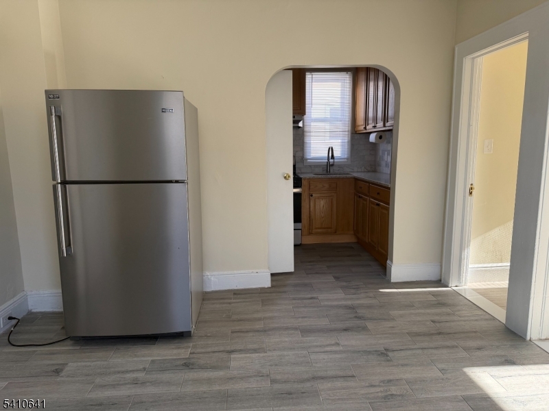 557 Gregory Avenue Passaic, NJ 07055 - Photo 3 of 8 a view of a kitchen with a refrigerator and a stove