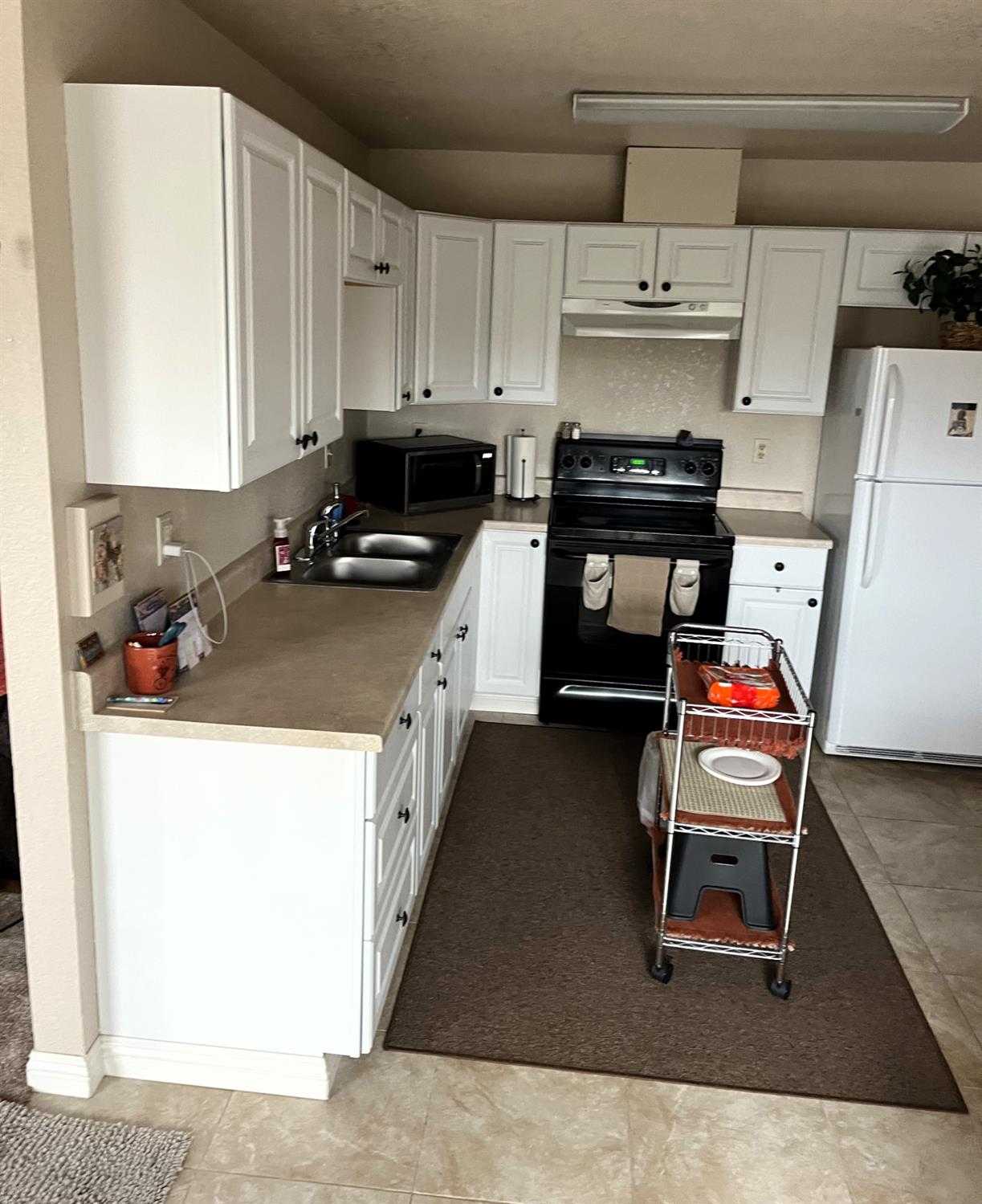 113 Atkinson Street Roseville, CA 95678 - Photo 11 of 22 a kitchen with a stove a refrigerator and cabinets