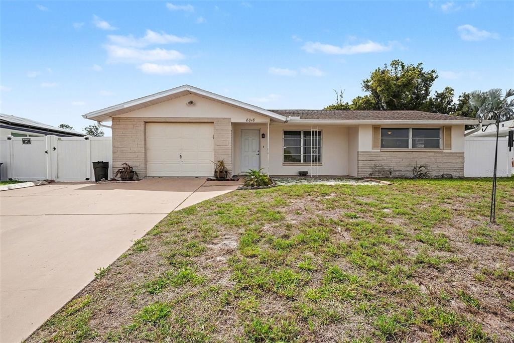 8018 Valmy Lane Port Richey, FL 34668 - Photo 1 of 1 a house with trees in front of it