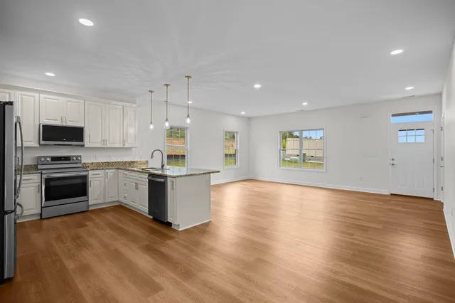 a kitchen with granite countertop a stove top oven and cabinets