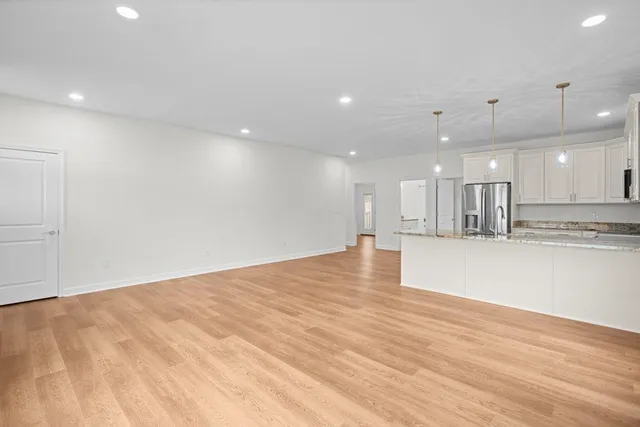 a view of an empty room with kitchen natural appliances