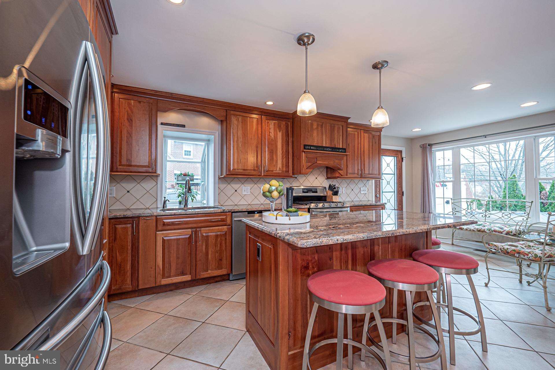 929 Westfield Road Springfield, PA 19064 - Photo 8 of 28 a kitchen with granite countertop wooden cabinets stainless steel appliances a dining table and chairs
