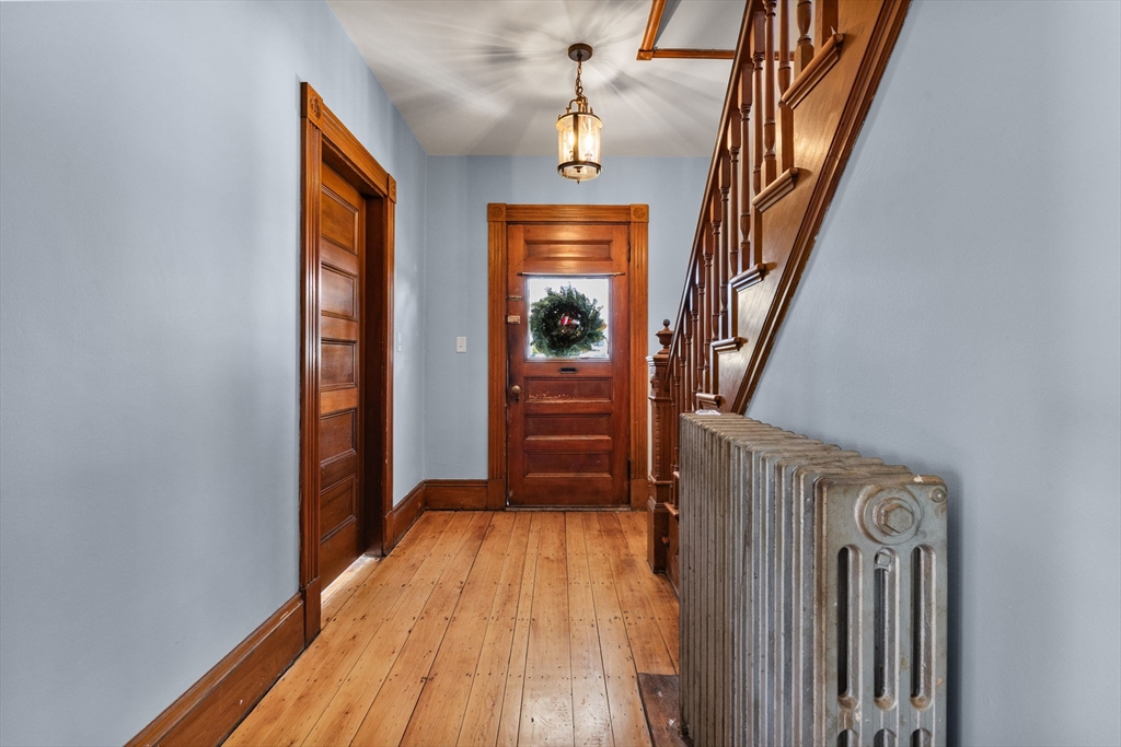 16 Pleasant Street Wakefield, MA 01880 - Photo 2 of 22 a view of a hallway with wooden floor and staircase