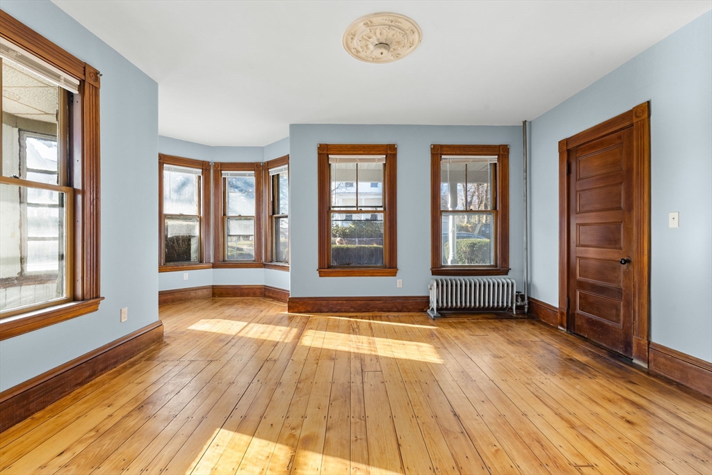 16 Pleasant Street Wakefield, MA 01880 - Photo 3 of 22 an empty room with wooden floor and windows