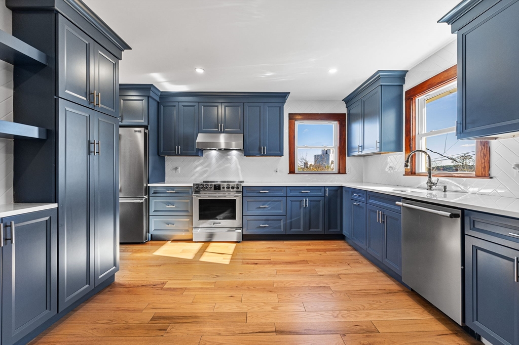 16 Pleasant Street Wakefield, MA 01880 - Photo 7 of 22 a large kitchen with stainless steel appliances granite countertop a stove refrigerator and cabinets