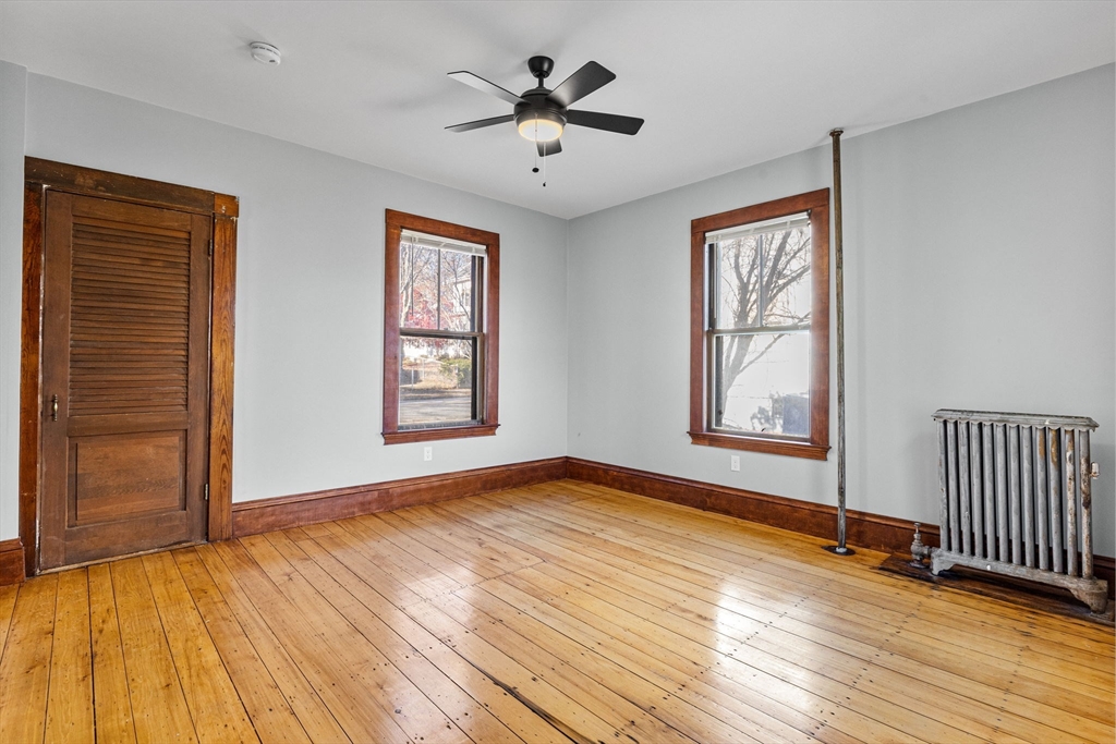 16 Pleasant Street Wakefield, MA 01880 - Photo 8 of 22 an empty room with wooden floor chandelier fan and windows