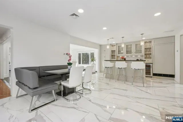 a room with lots of furniture and a view of kitchen