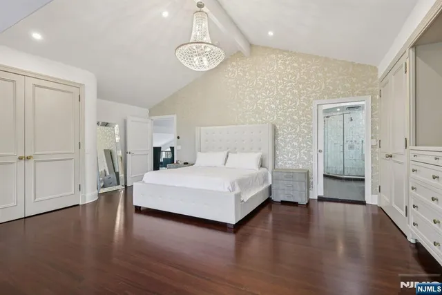 a spacious bedroom with a bed and a dresser