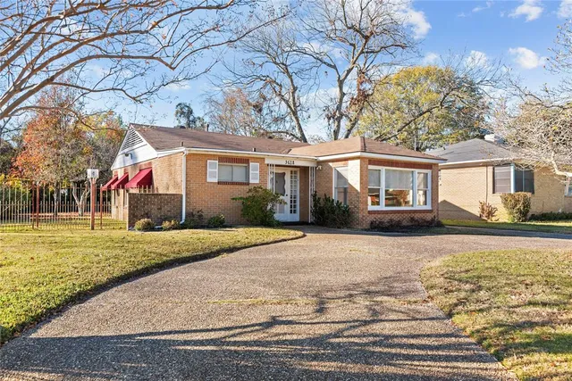 a front view of a house with a yard and trees