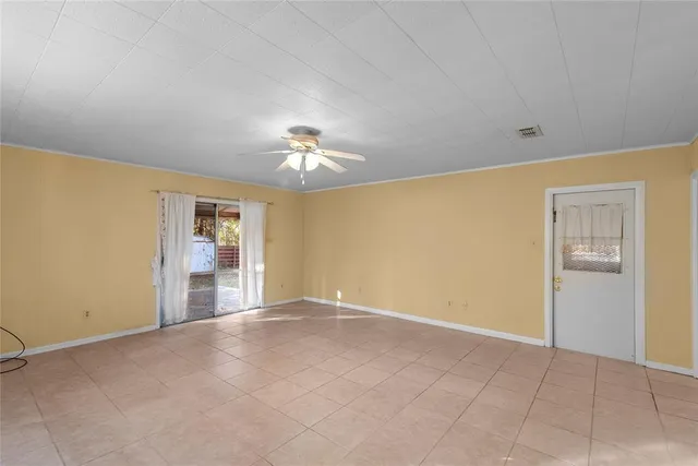 a view of an empty room with a chandelier fan