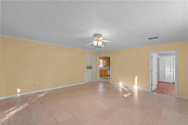 a view of an empty room with a chandelier fan
