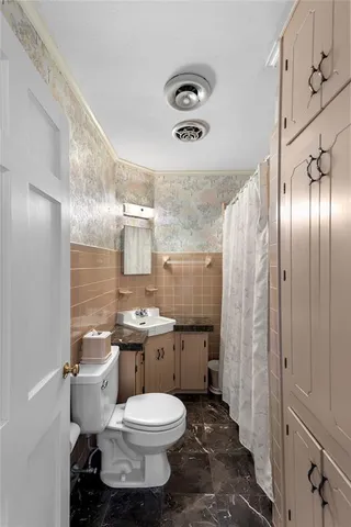 a bathroom with a toilet sink shower and mirror