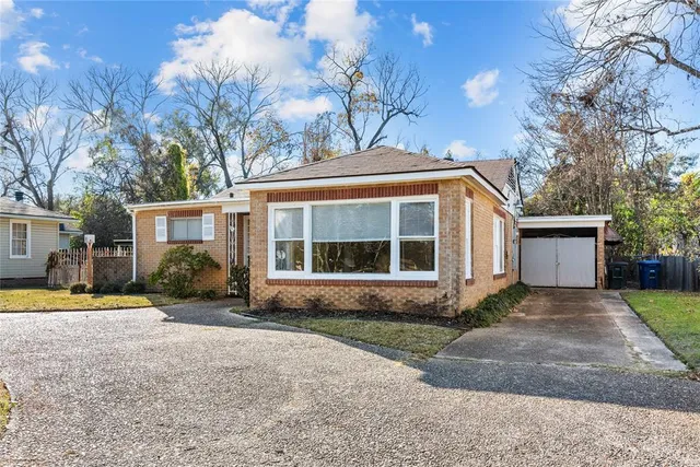 a front view of a house with a yard and potted plants