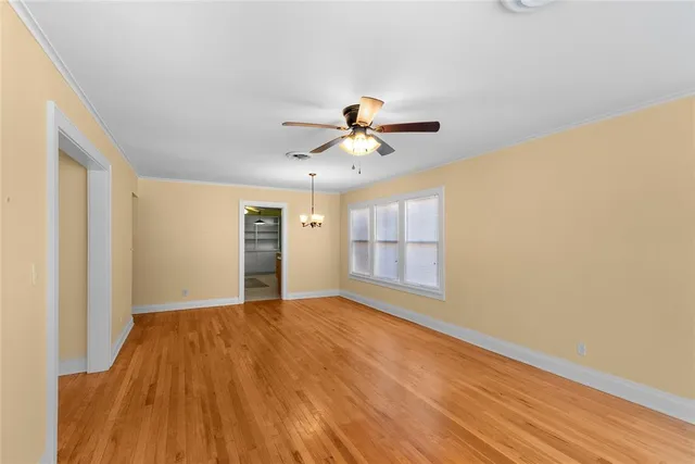 a view of a room with wooden floor and ceiling fan