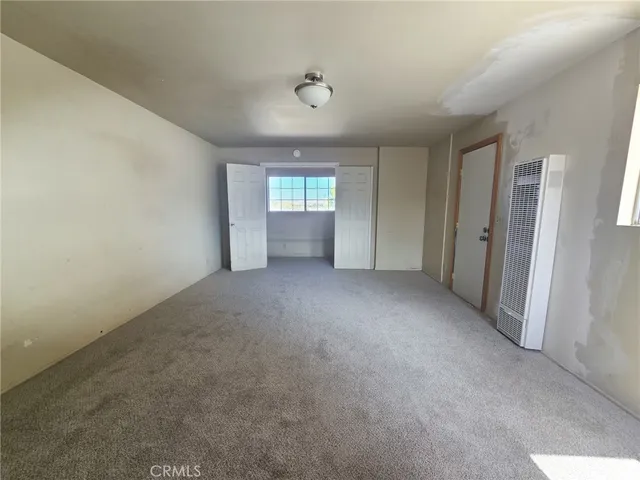 a view of a big room with windows and chandelier fan