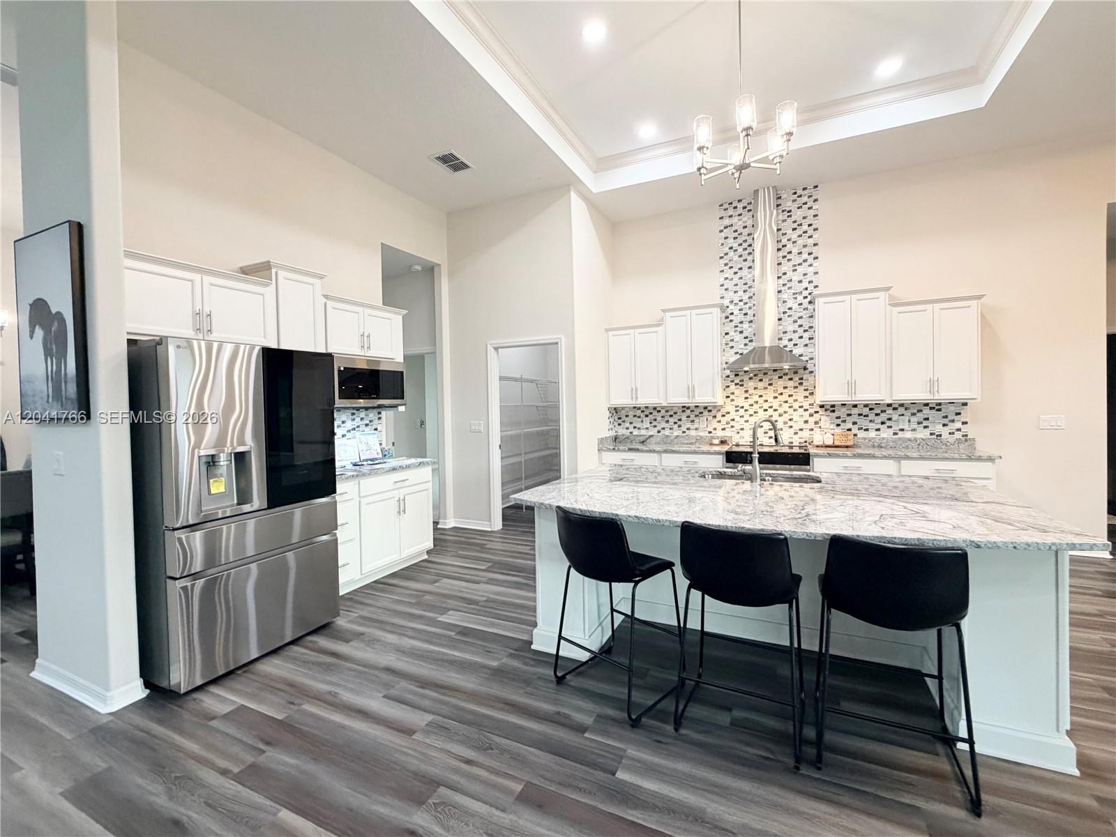 7041 Northeast 22nd Ct Road Ocala, FL 34479 - Photo 27 of 55 a kitchen with stainless steel appliances a dining table chairs refrigerator and cabinets