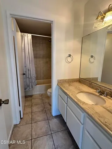 a white toilet and tub sitting next to a bathroom sink