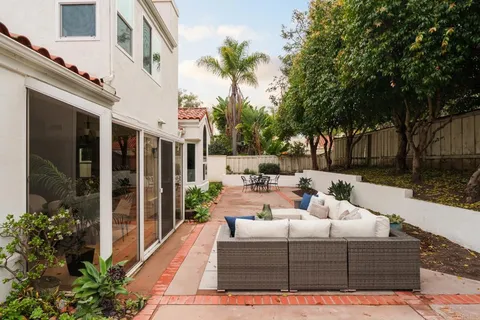 a view of a patio with couches table and chairs and potted plants