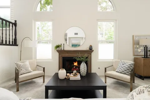 a living room with furniture a fireplace and a window