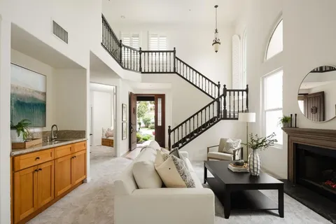 a living room with furniture a fireplace and a view of kitchen