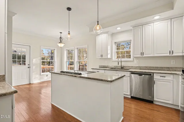 a large kitchen with granite countertop a sink and dishwasher a stove with wooden floor