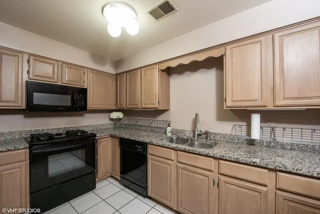 a kitchen with granite countertop white cabinets stainless steel appliances and a sink