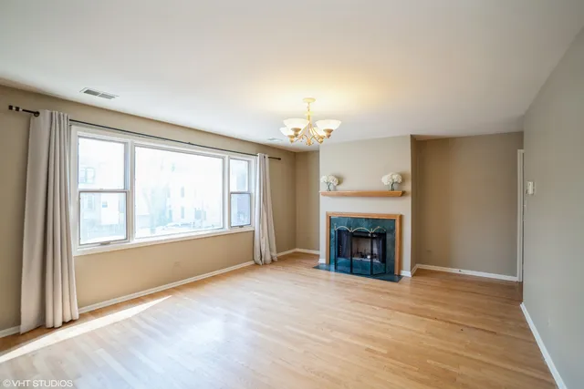 an empty room with fireplace and windows