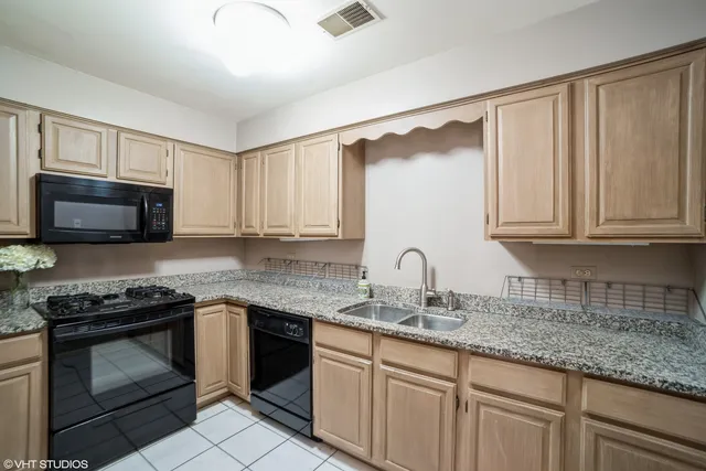 a kitchen with granite countertop white cabinets stainless steel appliances and a sink