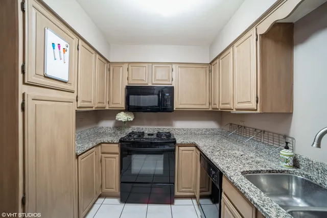 a kitchen with granite countertop a sink stove and cabinets