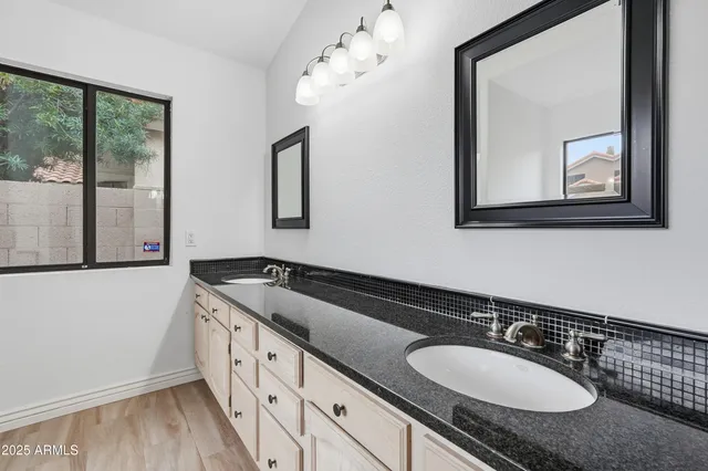a bathroom with a granite countertop sink a mirror and a window