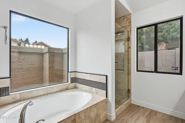 a bathroom with a tub and a large window