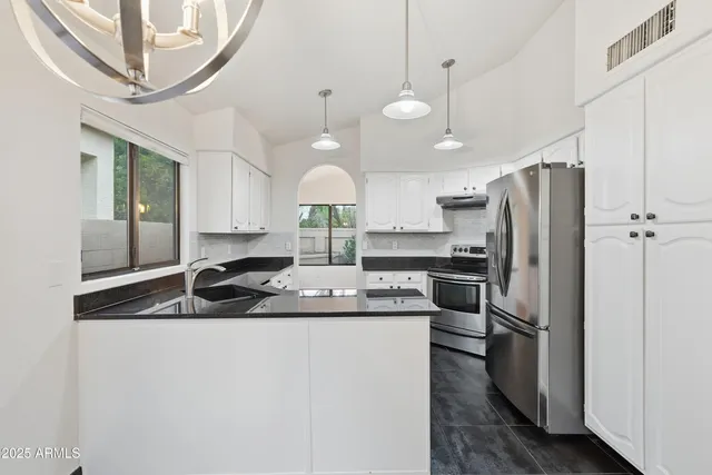 a kitchen with a refrigerator a sink and cabinets