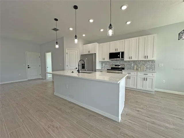 a kitchen with kitchen island microwave and cabinets