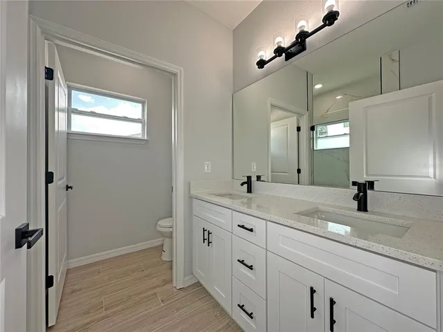 a bathroom with a granite countertop sink mirror and toilet