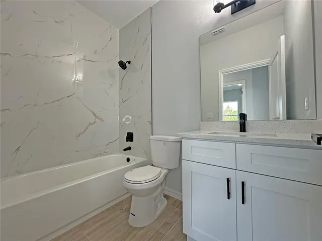 a bathroom with a toilet sink a mirror and shower