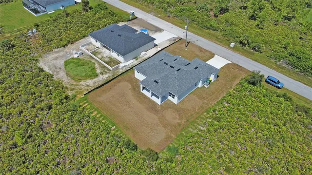 an aerial view of a house with a yard and trees