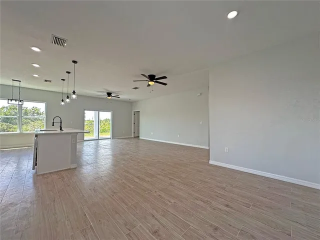 a view of a living room a kitchen with a wooden floor and a kitchen