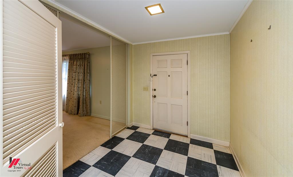 205 7th Street Northeast Springhill, LA 71075 - Photo 15 of 40 Foyer featuring checkerboard tile flooring, a paneled entry door, a mirrored wall, and a louvered bi-fold door
