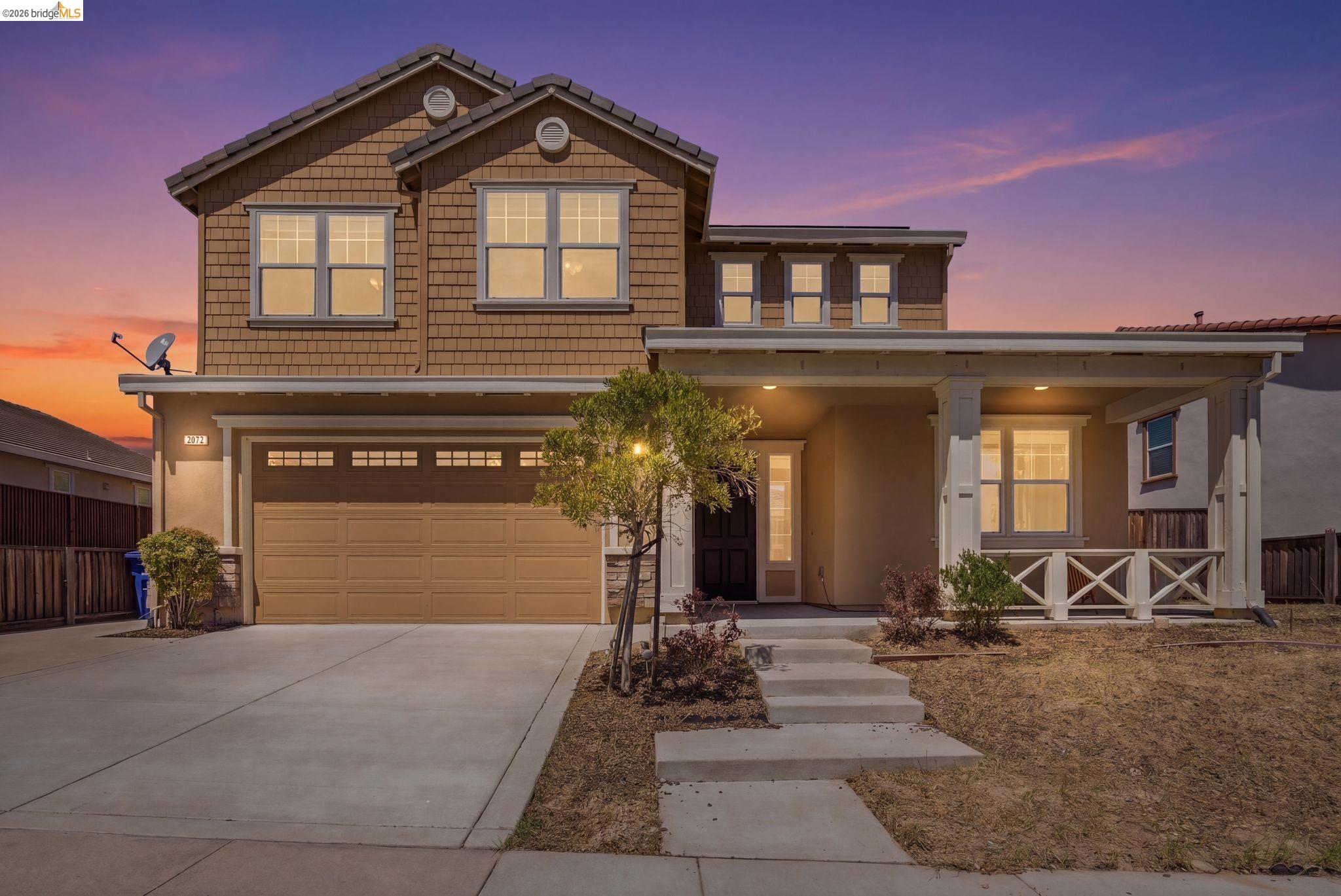 2972 Alves Ranch Road Pittsburg, CA 94565 - Photo 1 of 1 Two-story residence featuring a covered front porch with white railing details, an attached two-car garage, and horizontal siding on the upper level