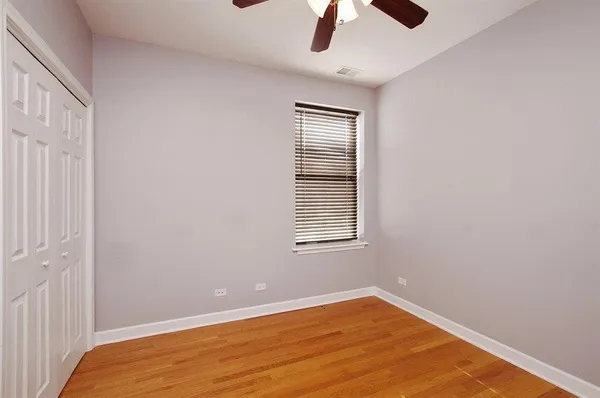 an empty room with a window and a ceiling fan