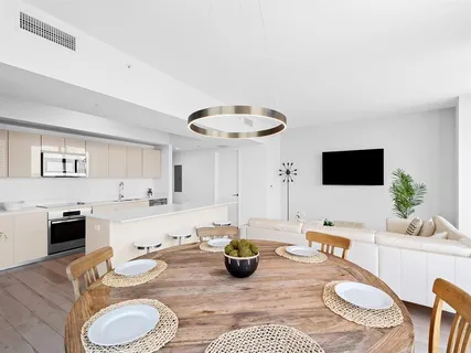 a kitchen with a sink a stove and white cabinets