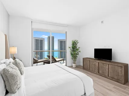 a bedroom with a bed and a flat screen tv