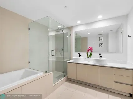 a bathroom with a tub sink and mirror