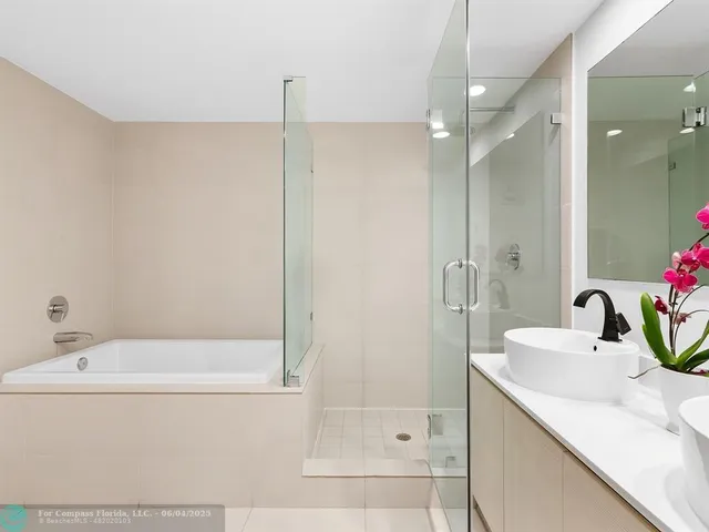 a bathroom with a tub sink and mirror