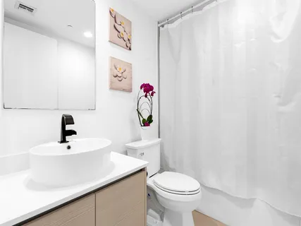 a bathroom with a sink a toilet and shower curtain